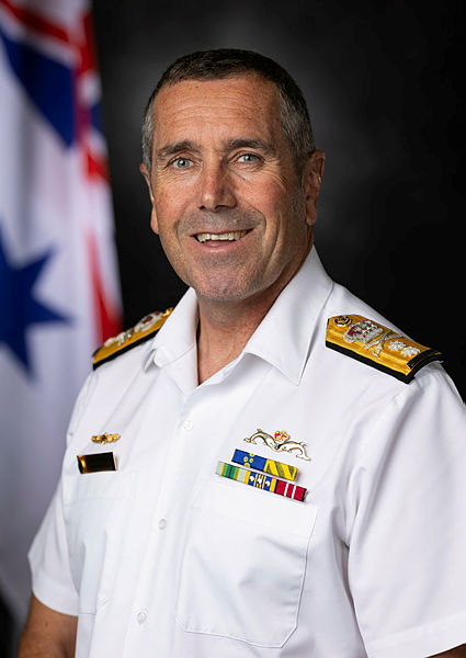 RADM Buckley official portrait in front of the Australian white ensign