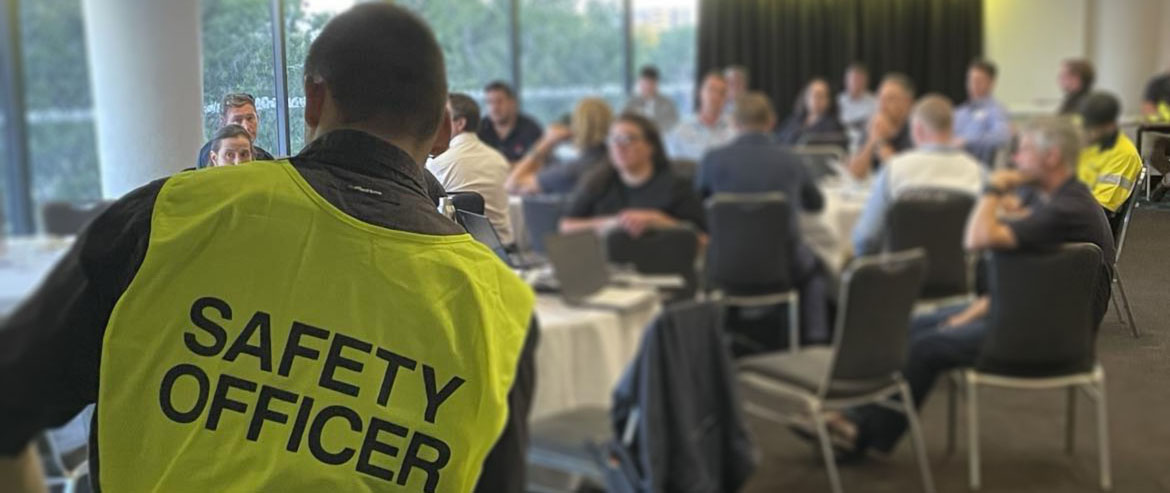 A safety officer leading a small group of people sitting in a conference room