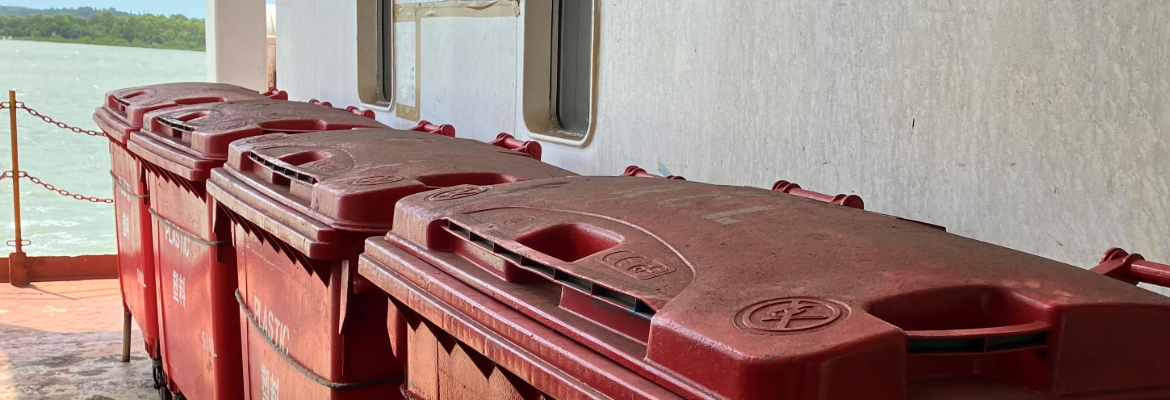 Large red recycling hoppers on board a vessel