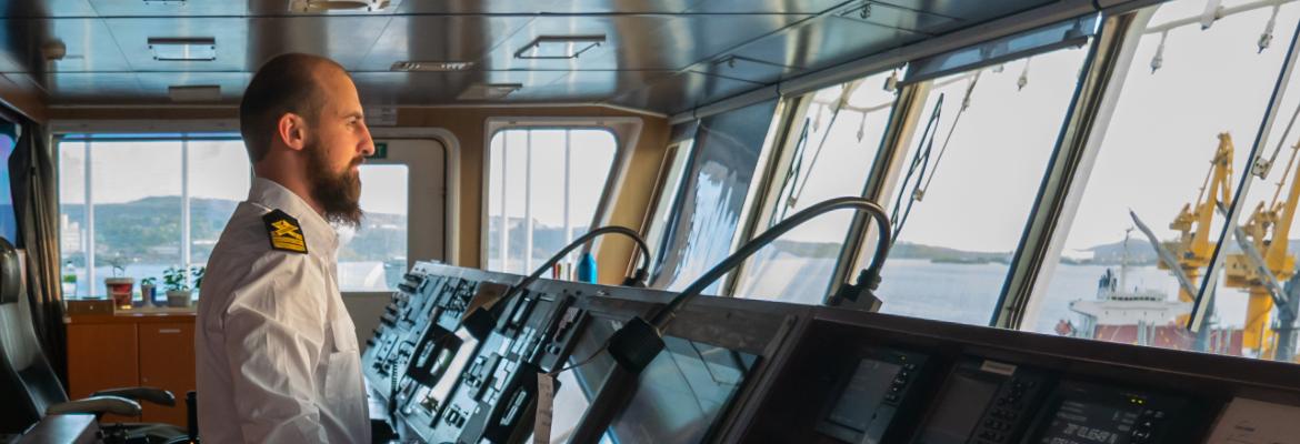 An officer at the helm in the Bridge of a vessel