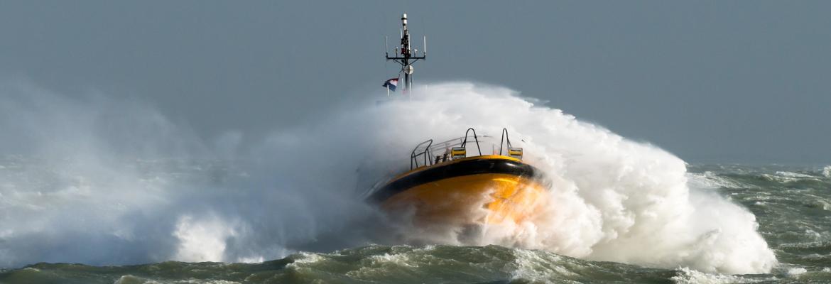 Sea spray covering a vessel crashing through waves 