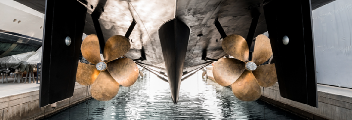 The hull of a ship lifted out of the water showing the keel and two propellors 