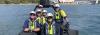 A group of AMSA inspectors on a boat in Sydney Harbour. You can see parts of the Sydney Harbour Bridge and the Sydney Opera House in the background. 